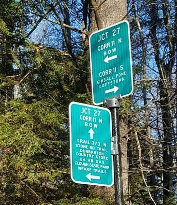 Signs in forest telling which way to go for snowmobile trails